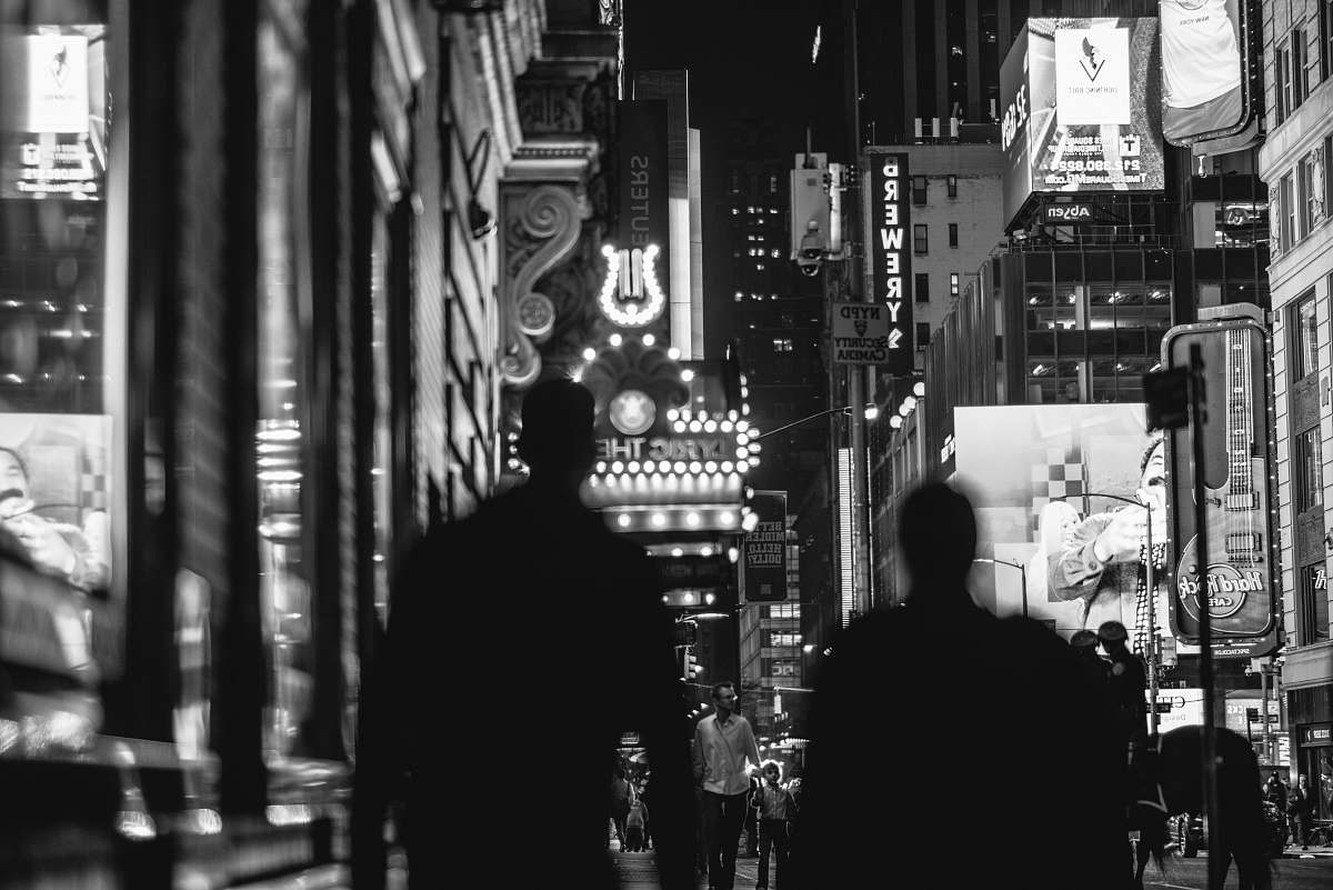 black-and-white grayscale photo of two person standing on hallway night